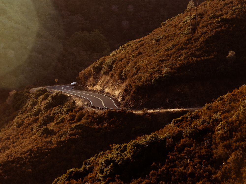Vía pavimentada que atraviesa una ladera de montaña.